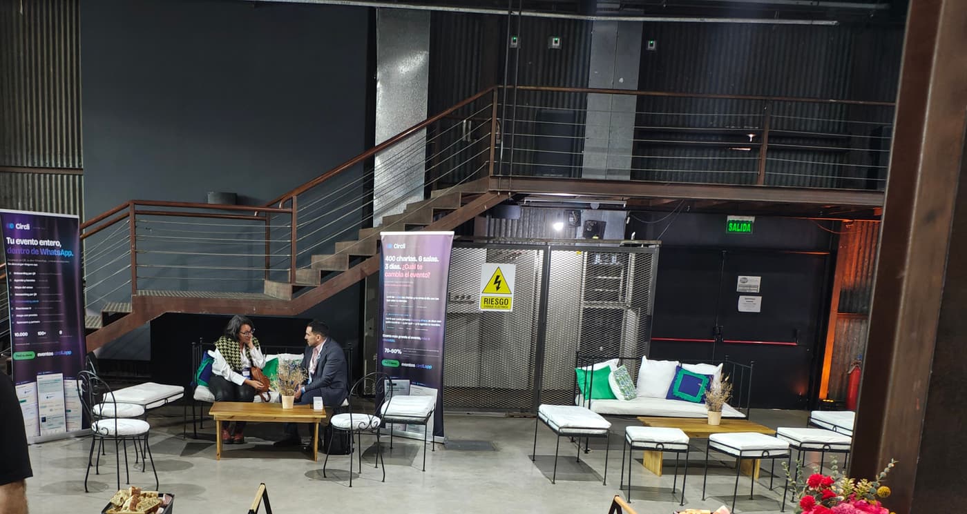 Espacio de networking con dos pendones de Circli, sillones y dos personas reunidas en una mesa baja